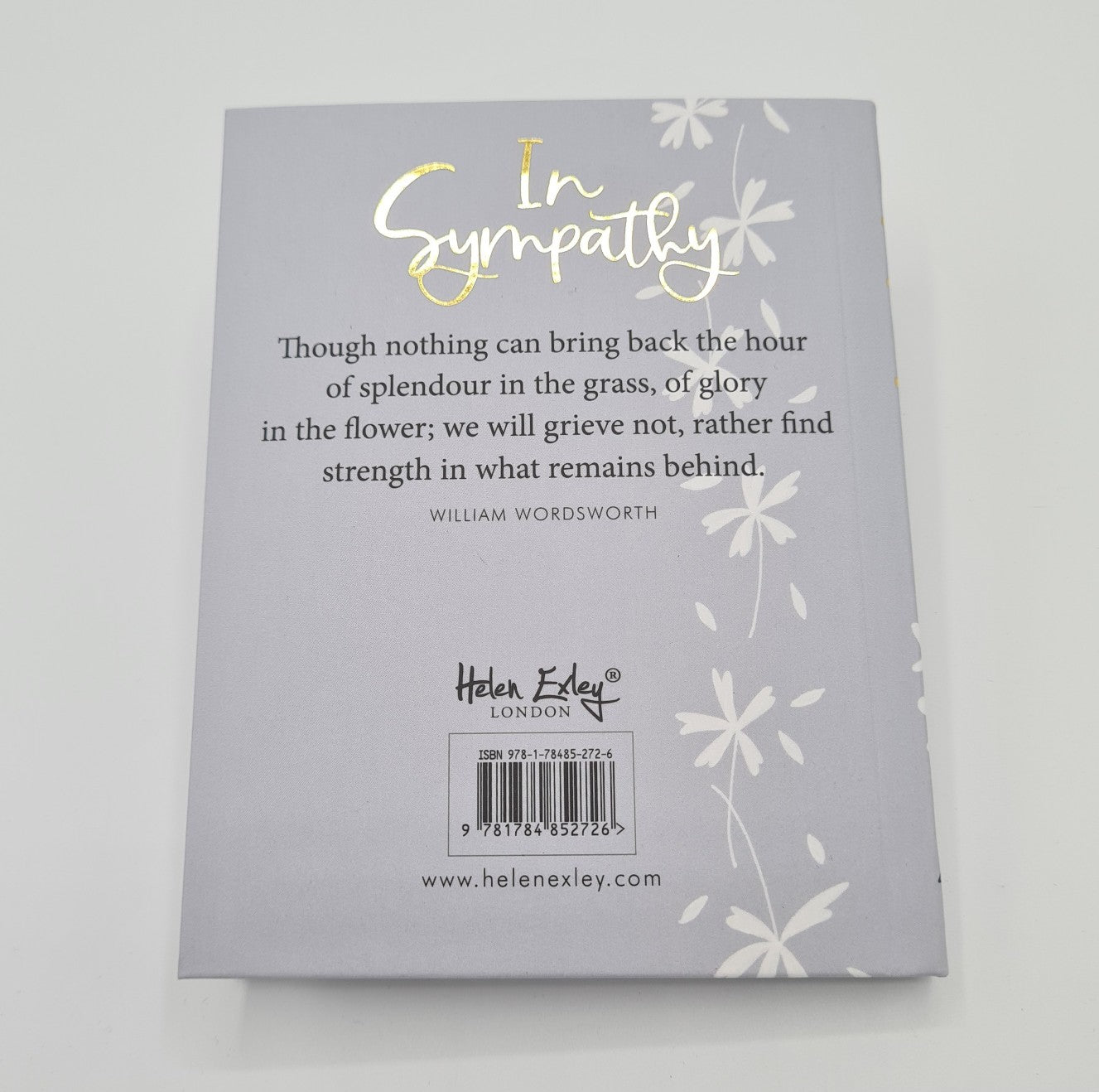 Back cover of sympathy book. It is grey in colour and has the words "In Sympathy" written in gold font. There is a line of white flowers drawn from top to bottom on the page. The cover also features the quotation "Though nothing can bring back the hour of splendour in the grass, of glory in the flower; we will grieve not, rather find strength in what remains behind" from William Wordsworth.