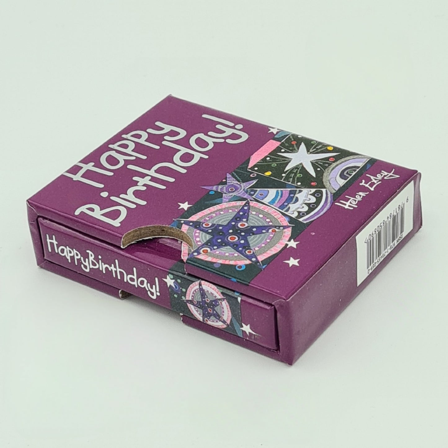 Little purple book entitled "Happy Birthday" encased in its own purple sleeve. The title of the book is visible on the top of the sleeve and on the spine of the book.