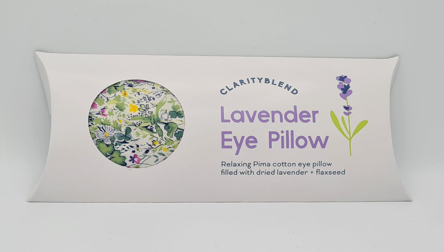 White box containing Clarity Blend Lavender Eye Pillow, described as "Relaxing Pima cotton eye pillow filled with dried lavender and flaxseed". There is a round window in the box through which you can see a green garden pattern with yellow, pink and white flowers.