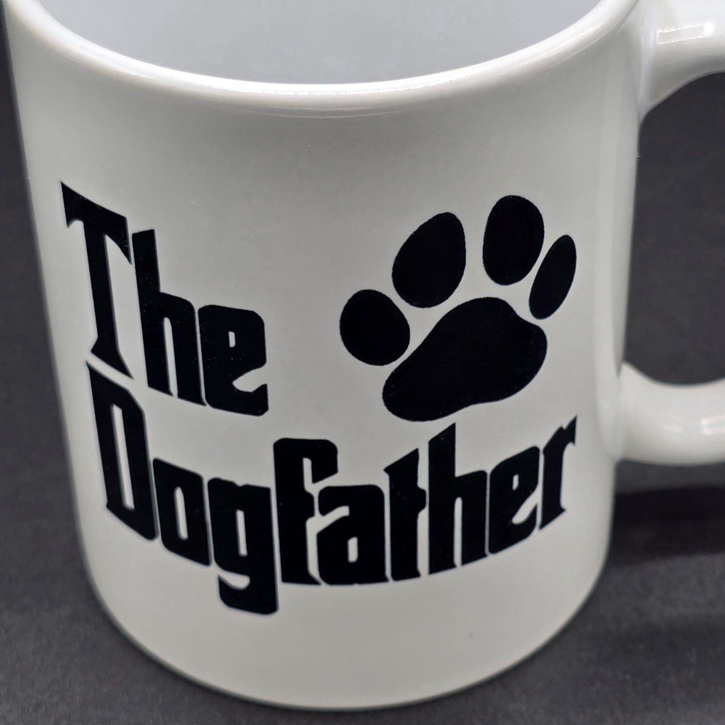 Close up of white mug with black text "The Dogfather" and a black paw print.