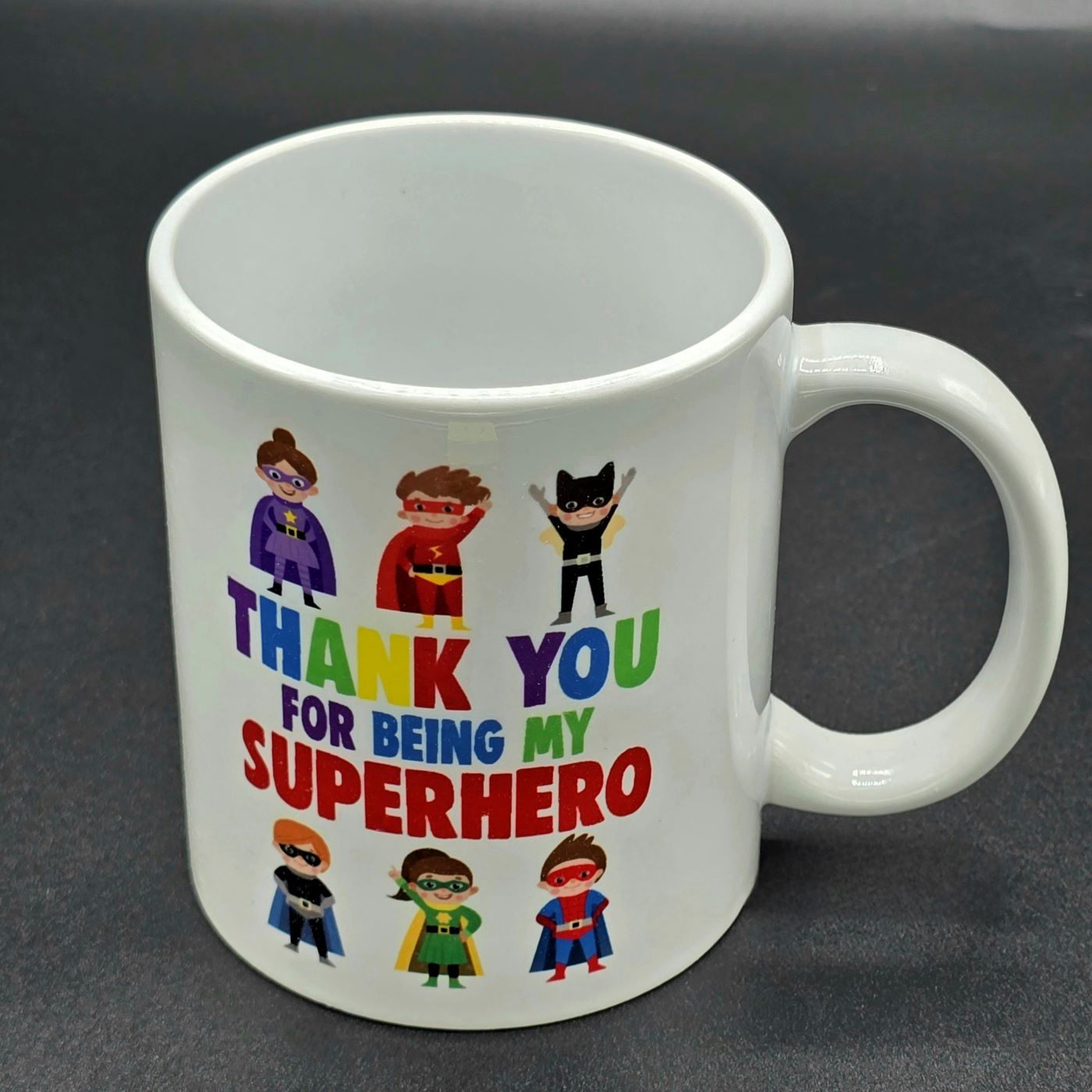 White mug with illustrations of six superheroes and the wording "Thank You for Being my Superhero".