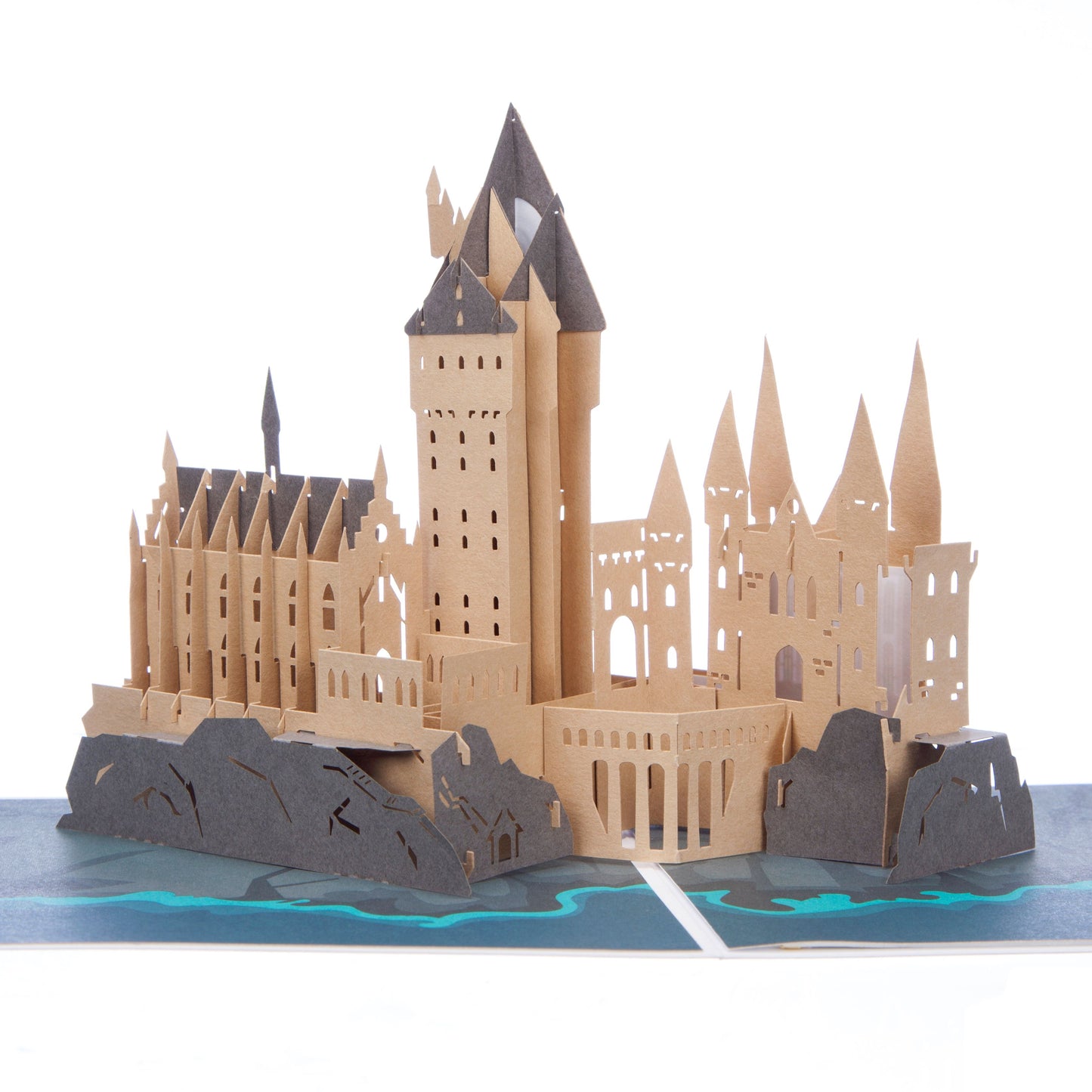 Close up of Hogwarts Castle pop up card showing a "popped up" Hogwarts Castle sitting on rocks and surrounded by sea. The castle is light brown in colour.
