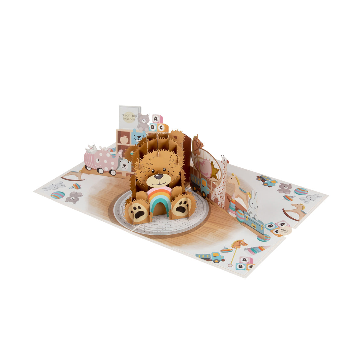 Aerial view of New Baby Bear pop up card showing a "popped up" brown teddy bear holding a rainbow, and sitting in a nursery surrounded by lots of toys including building blocks and a rocking horse.