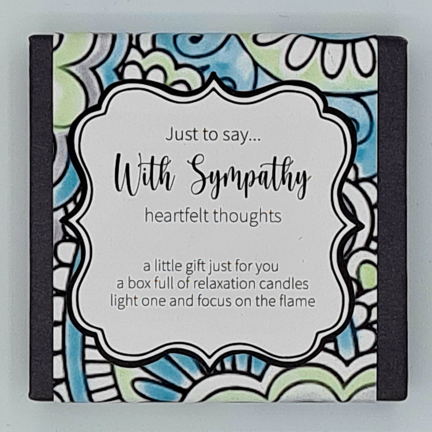 Small black square box with green, purple and blue patterned label with a white text box saying "Just to say...With Sympathy, heartfelt thoughts. A little gift just for you, a box full of relaxation candles, light one and focus on the flame".
