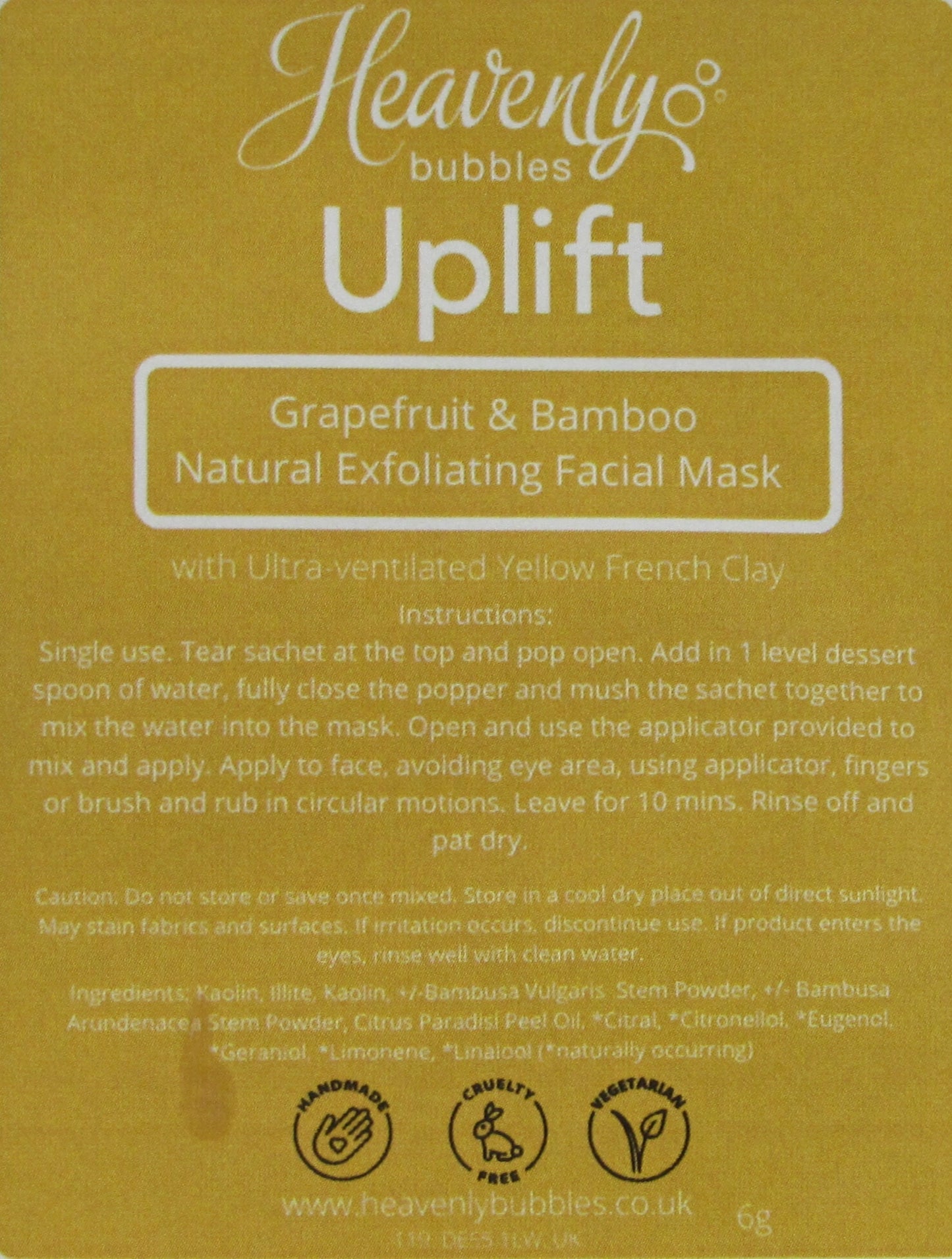 Close up of yellow label from Heavenly Bubbles Uplift Grapefruit & Bamboo Natural Exfoliating Facial Mask with Ultra-Ventilated Yellow French Clay. It shows the instructions for use and list of ingredients.