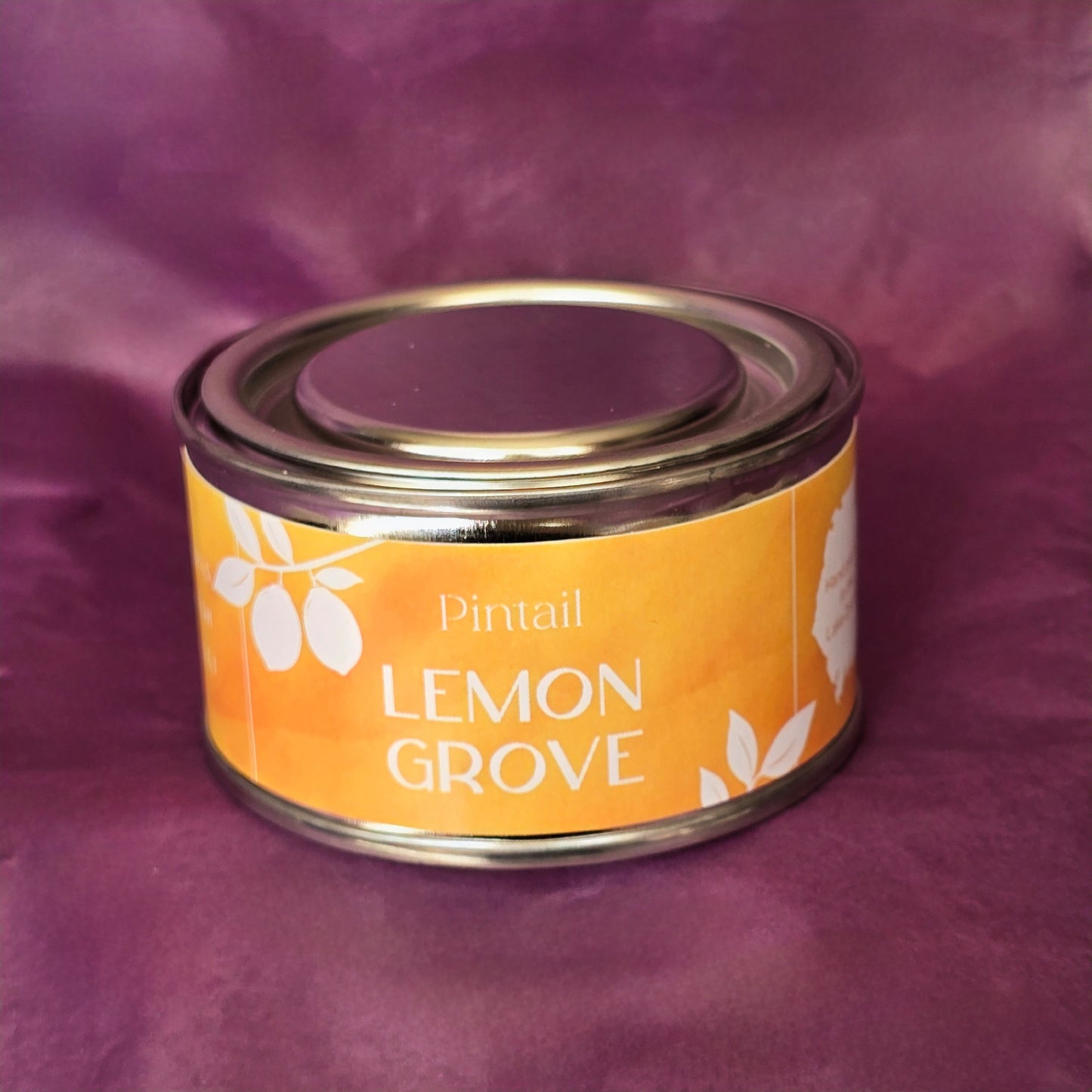Petite paint pot candle tin from Pintail Candles. The yellow coloured label on the tin says "Lemon Grove" and features a white illustration of lemons hanging on a branch.