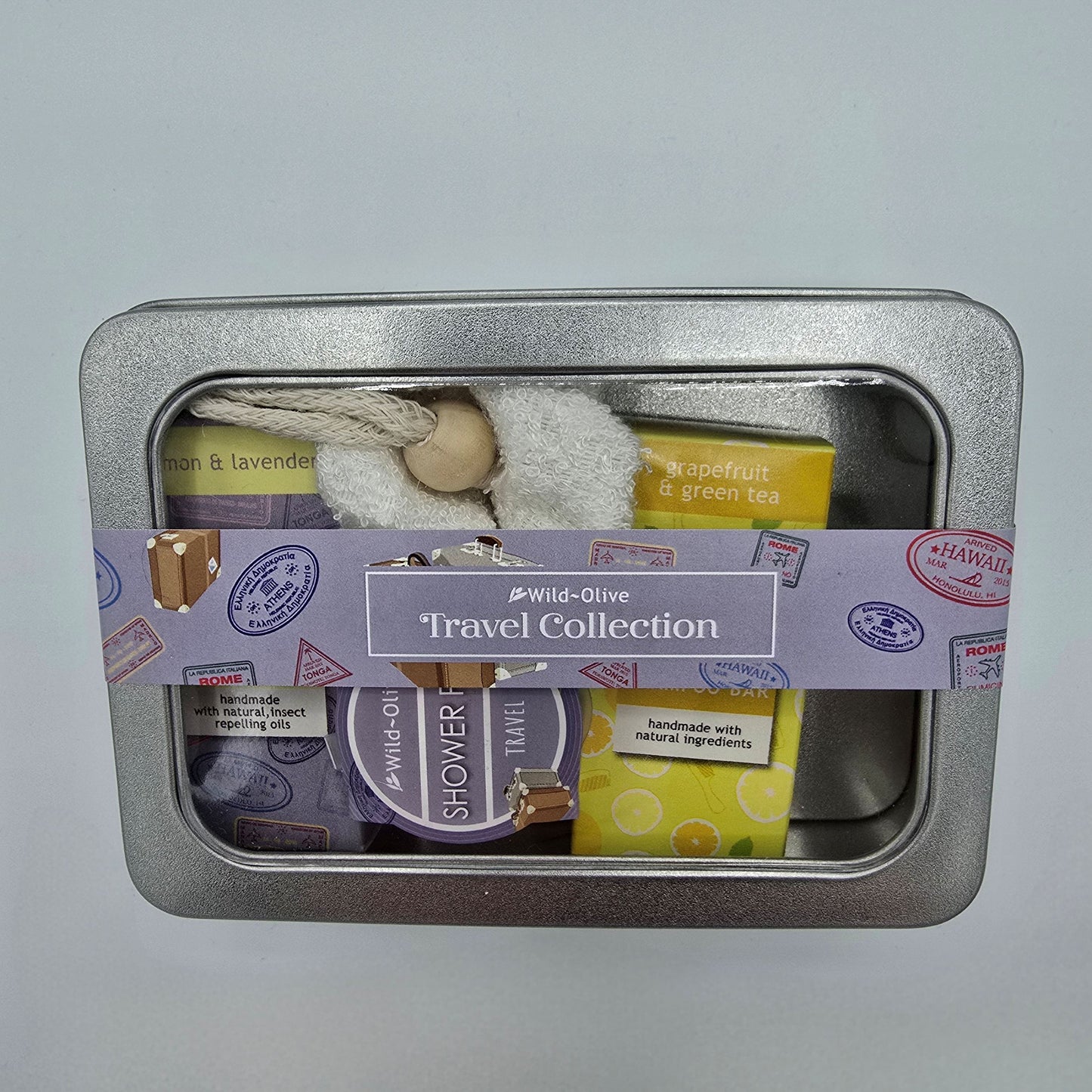 Silver gift tin containing Travel Collection selection of bath and shower products from Wild Olive