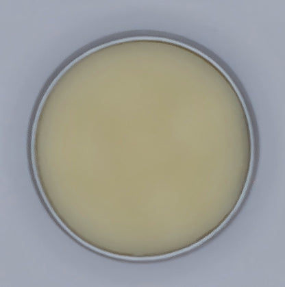 Inside of small silver tin showing natural coloured solid lip balm