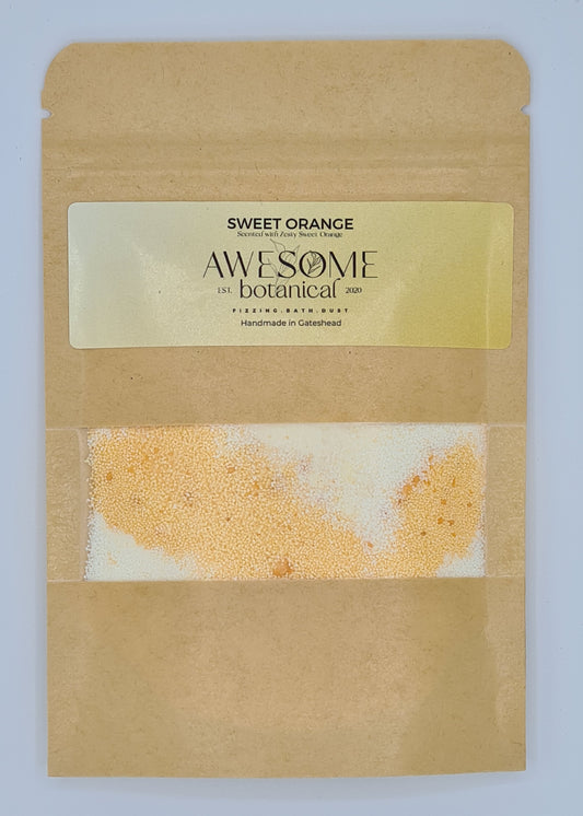 Brown kraft pouch with orange label from Awesome Botanical stating Sweet Orange, scented with zesty sweet orange. There is a small clear window within the pouch showing the orange and white bath dust. 