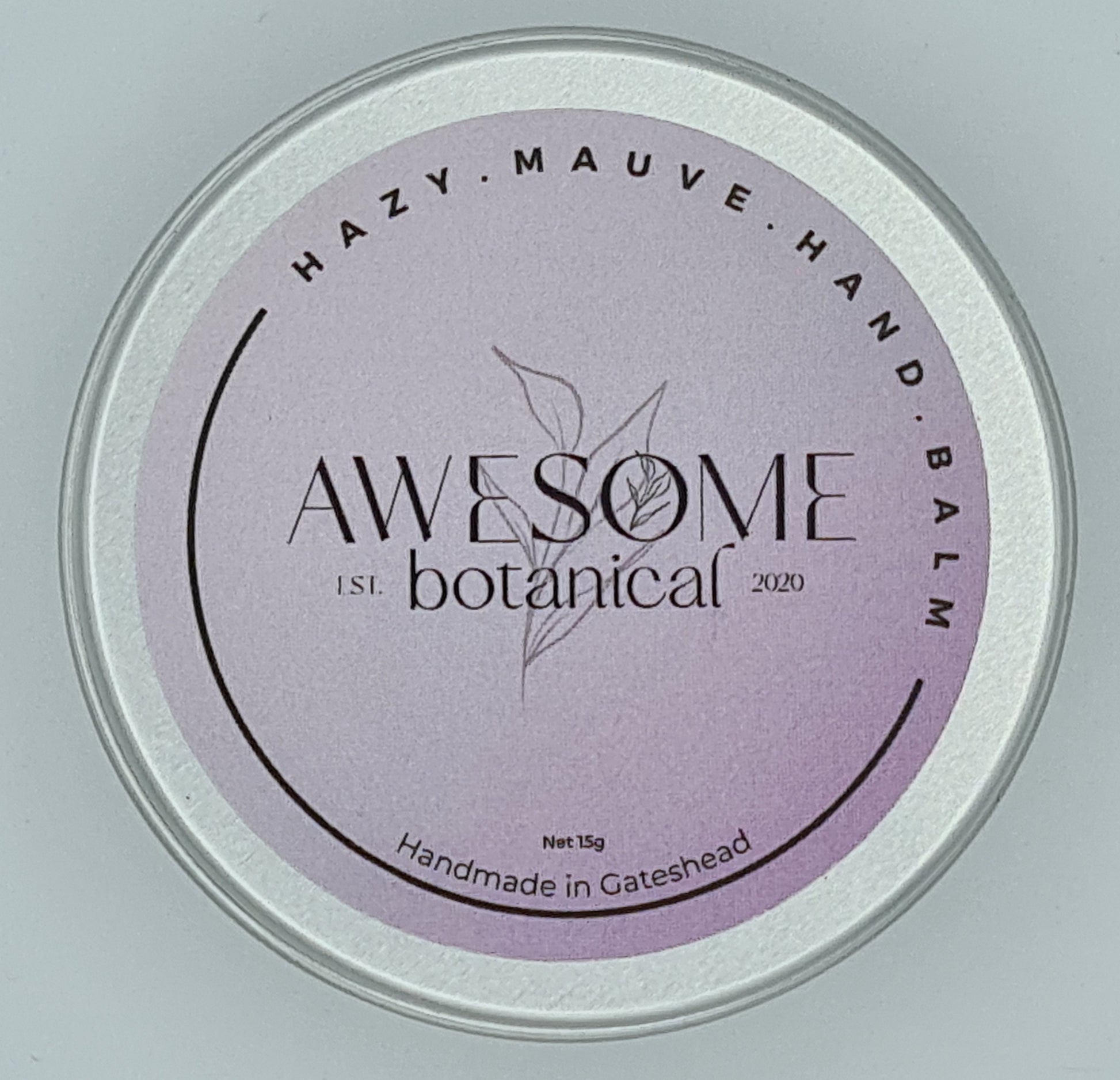 Silver tin with lilac label from Awesome Botanical stating Hazy Mauve Hand Balm.