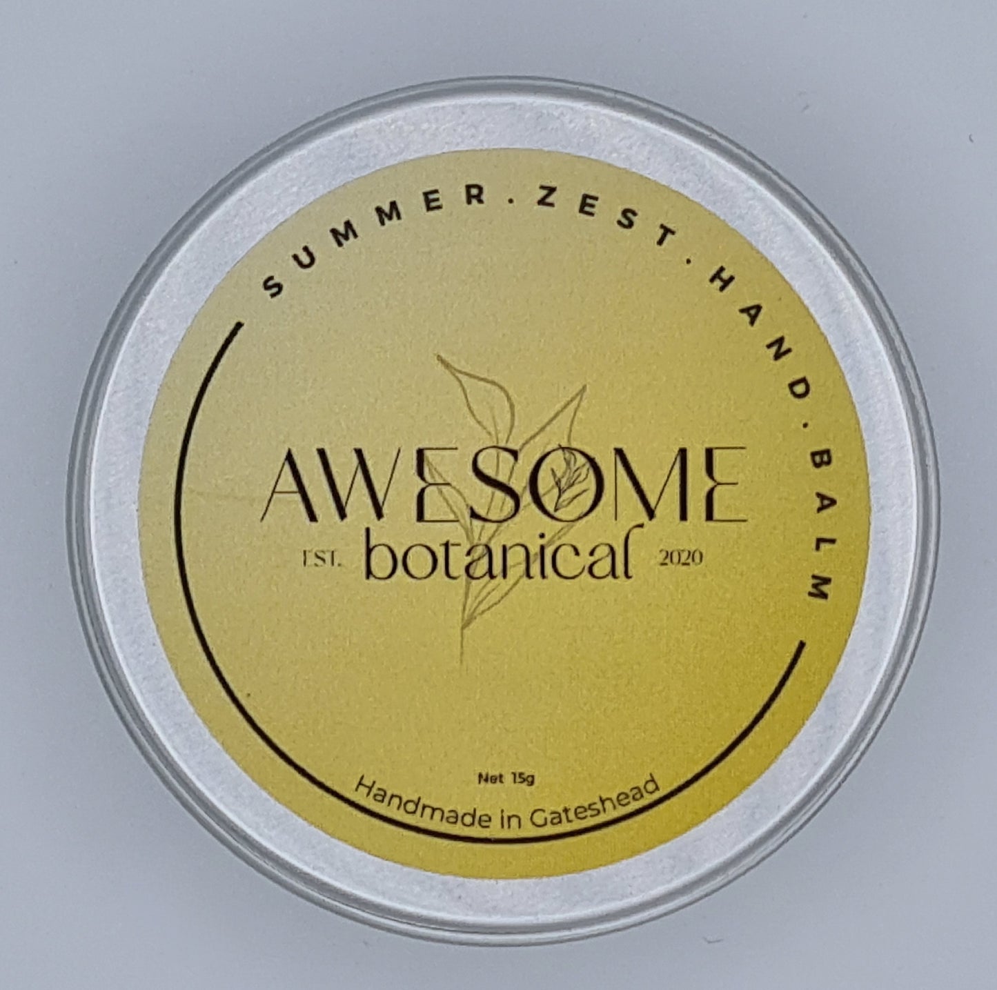 Silver tin with orange label from Awesome Botanical stating Summer Zest Hand Balm.