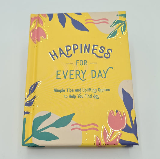 Yellow book with illustrations of pink, blue and green foliage in the corners. The book title, "Happiness for Every Day" is written in the middle of the page in blue and green text with the description "Simple Tips and Uplifting Quotes to help you find joy" underneath the title. 