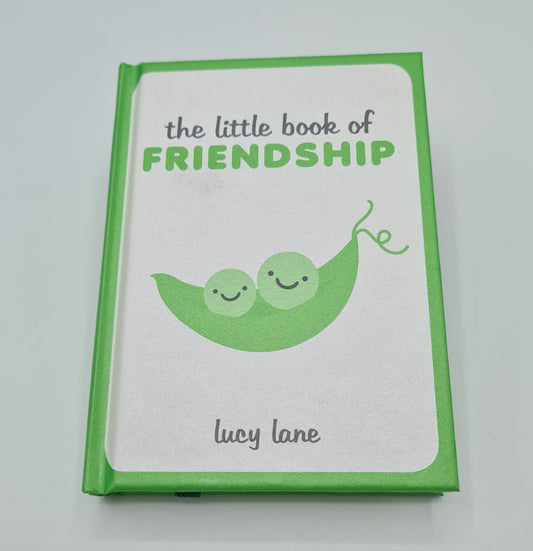 Green and silver book entitled "The little book of Friendship" with an illustration of two peas in a pod and the author's name Lucy Lane at the bottom of the cover