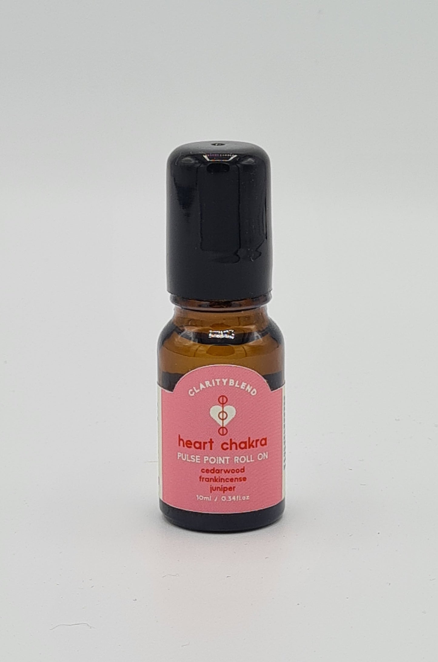 Small brown glass bottle with pink label saying Clarity Blend Heart Chakra Pulse Point Roll On