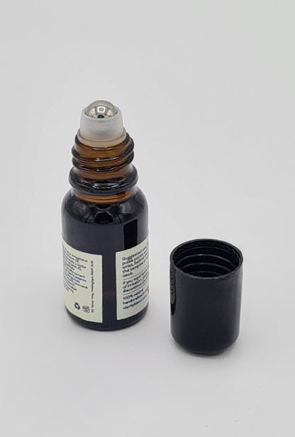 Brown glass bottle of Clarity Blend aromatherapy Pulse Point Roll On showing metal roller ball with black lid sitting next to bottle