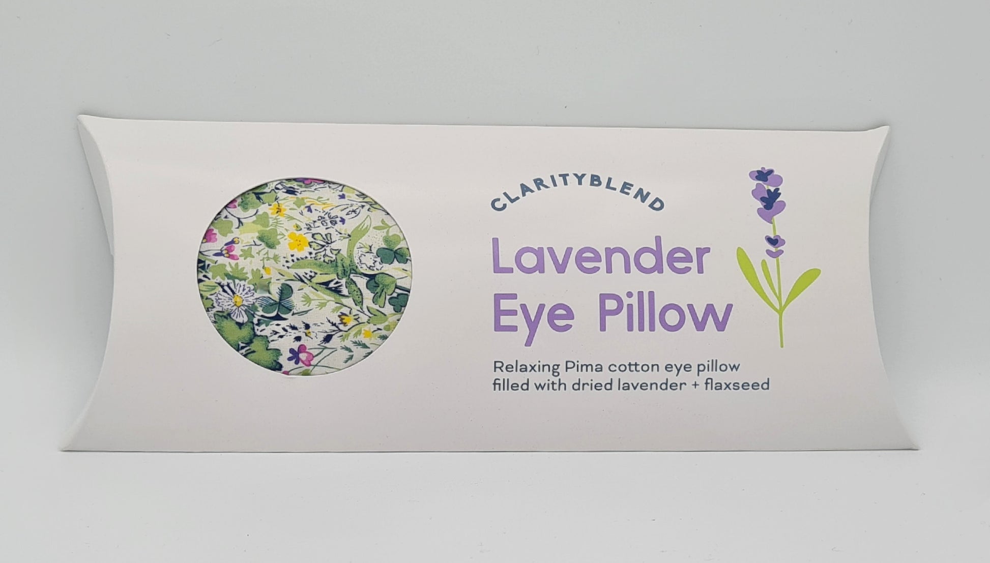 White box containing Clarity Blend Lavender Eye Pillow, described as "Relaxing Pima cotton eye pillow filled with dried lavender and flaxseed". There is a round window in the box through which you can see a green garden pattern with yellow, pink and white flowers. 