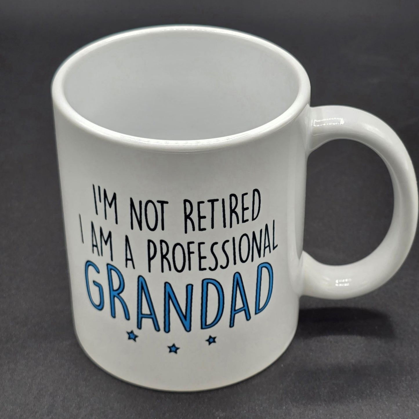 White mug with handle and the text "I'm not retired. I am a professional grandad".