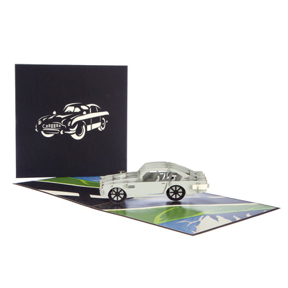 Two images - the left hand image shows the front of the card coloured black with a white cut out of the Aston Martin while the second image shows the card opened out with the Aston Martin "popped up".