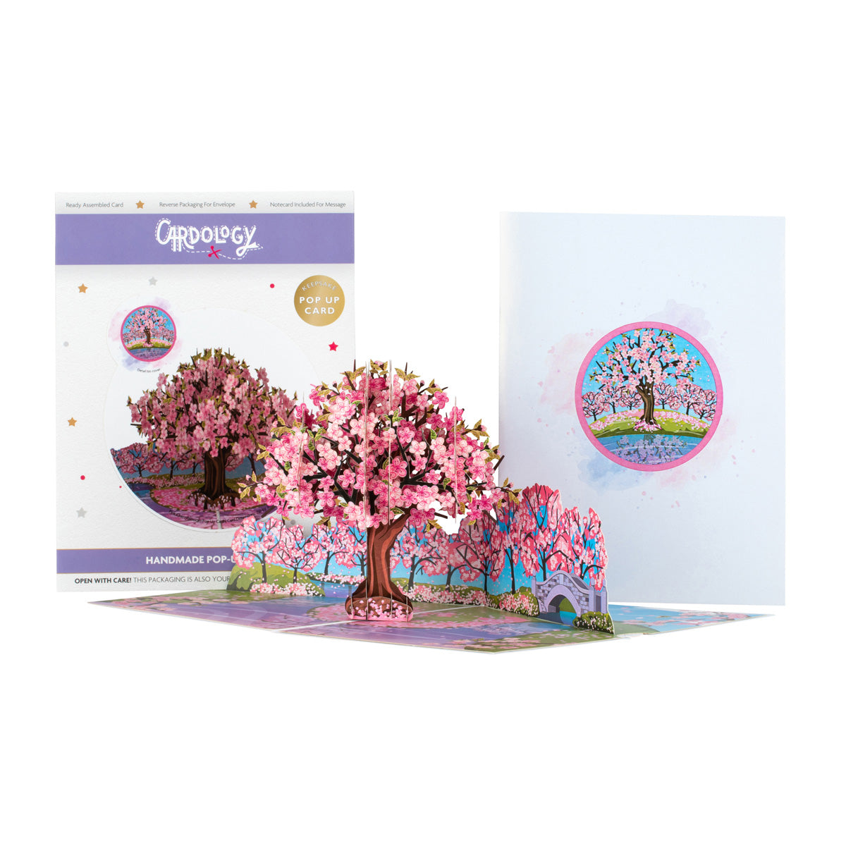 Three images together in one - the image on the left hand side shows the packaging for the Cherry Blossom Tree card, the middle image shows the card open and "popped up" while the image on the right hand side shows the front cover of the card with an illustration of the cherry blossom tree inside a circle.