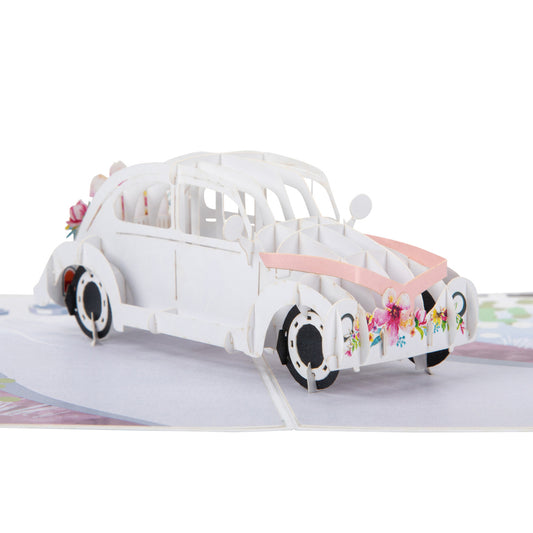 Close up of Wedding Car pop up card showing a pop up white wedding car with a pink ribbon tied to the front bonnet and flowers on the front bumper.