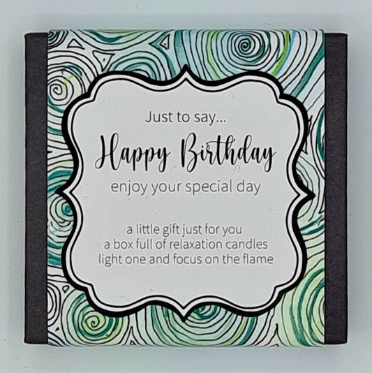 Small black square box with a label with green and turquoise swirls and a white text box saying "Just to say...Happy Birthday, enjoy your special day. A little gift just for you, a box full of relaxation candles, light one and focus on the flame". 