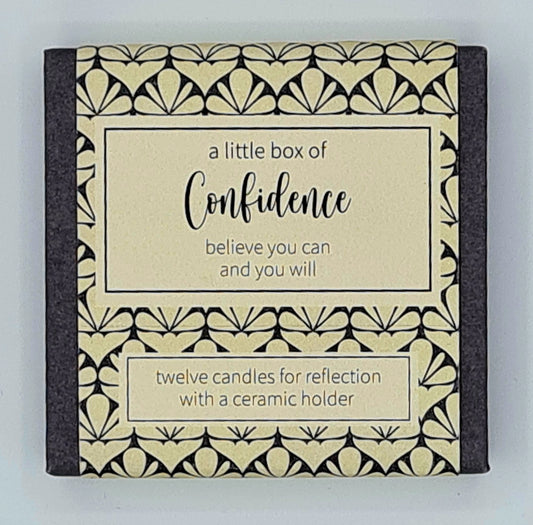 Small square box with a cream label and a text box saying "A Little Box of Confidence, believe you can and you will". There is a second smaller text box saying "twelve candles for reflection with a ceramic holder". 