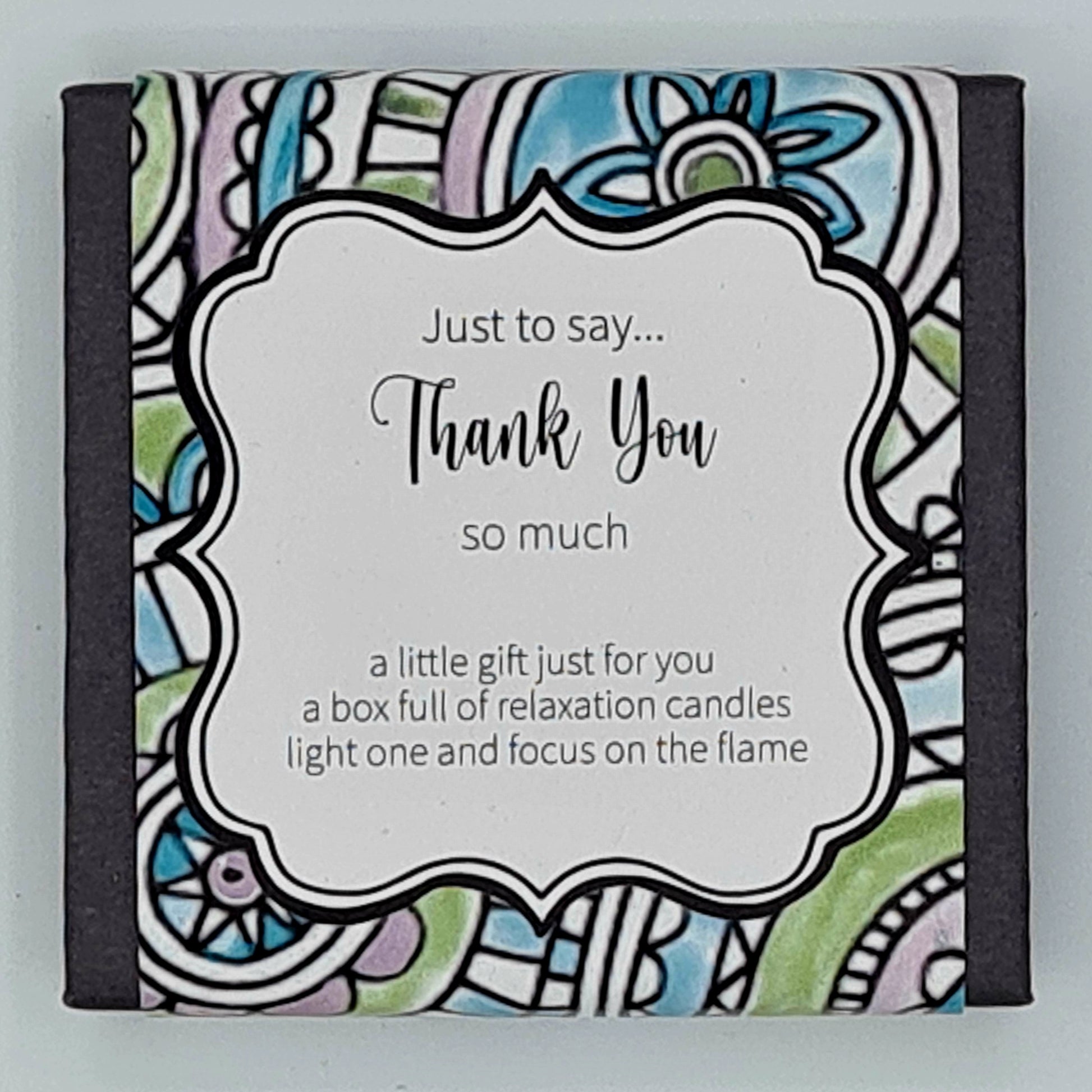 Small black square box with a multi coloured label and white text box saying "Just to say...Thank You so much. A little gift just for you, a box full of relaxation candles, light one and focus on the flame". 