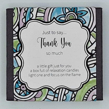 Small black square box with a multi coloured label and white text box saying "Just to say...Thank You so much. A little gift just for you, a box full of relaxation candles, light one and focus on the flame". 