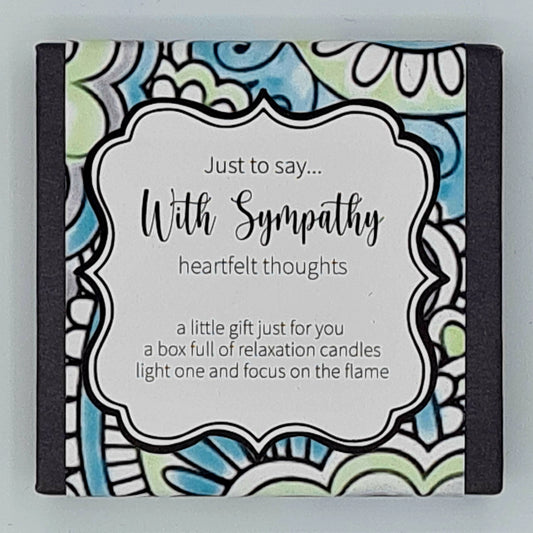 Small black square box with green, purple and blue patterned label with a white text box saying "Just to say...With Sympathy, heartfelt thoughts. A little gift just for you, a box full of relaxation candles, light one and focus on the flame". 