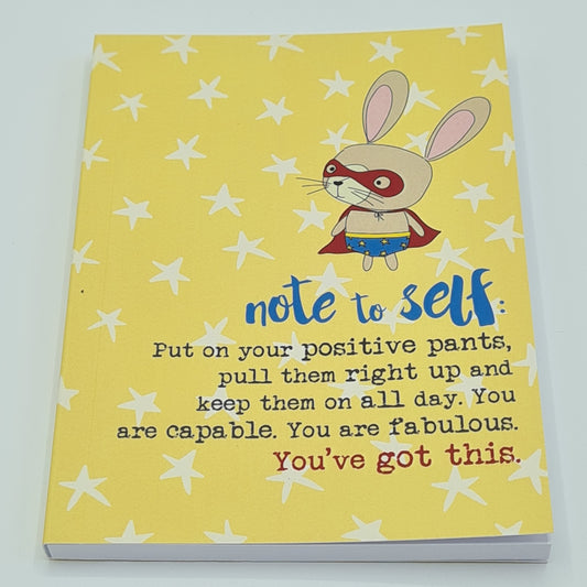 A6 notebook with yellow front cover covered in white stars, featuring a drawing of a rabbit dressed as a superhero wearing a mask and cape and text which reads "Note to Self: Put on your positive pants, pull them right up and keep them on all day. You are capable. You are fabulous. You've got this".