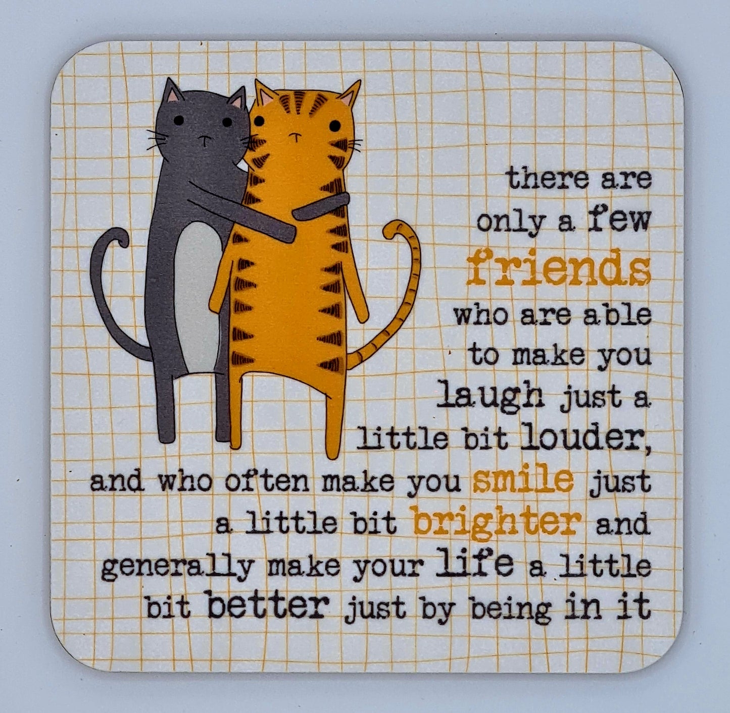 Coaster with drawing of grey cat and orange cat with stripes hugging. The slogan says "There are only a few friends who are able to make you laugh just a little bit louder, and who often make you smile just a little bit brighter and generally make your life a little bit better just by being in it".