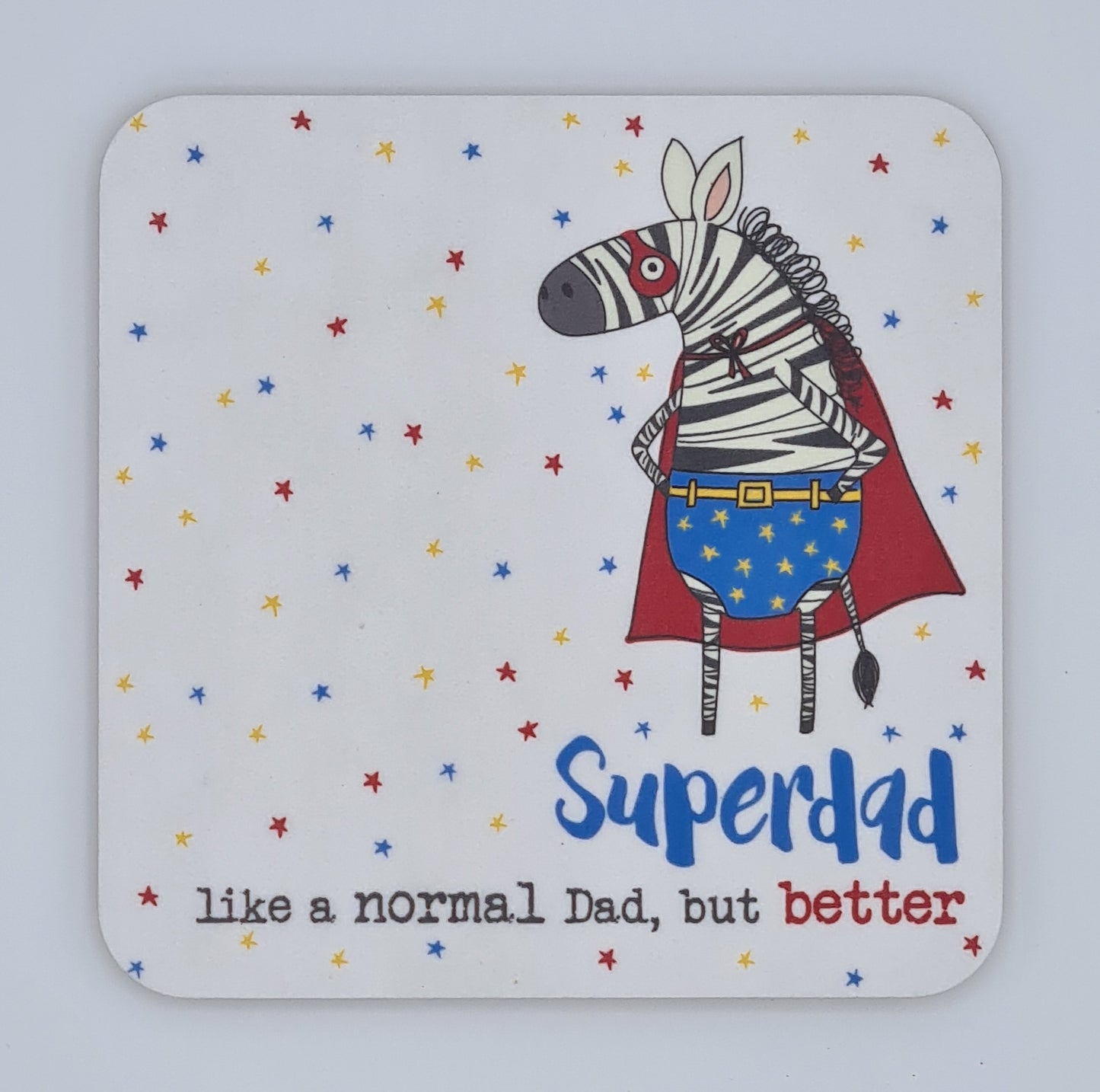 Square coaster with red, yellow and blue stars and a drawing of a zebra dressed as a superhero with red eye mask, blue starry pants and a red cape. Text below states "Superdad, like a normal Dad, but better". 