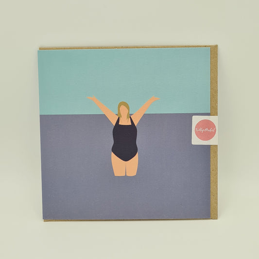 Front of greetings card from Fiddy & Mabel entitled "I Love the Water". It features an illustration of a woman from the front. She is wearing a dark swimsuit and is standing in the water with her arms held high in jubilation. 