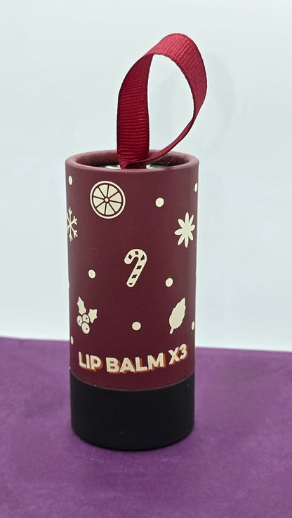 Lip balm container with decorative design on a purple surface