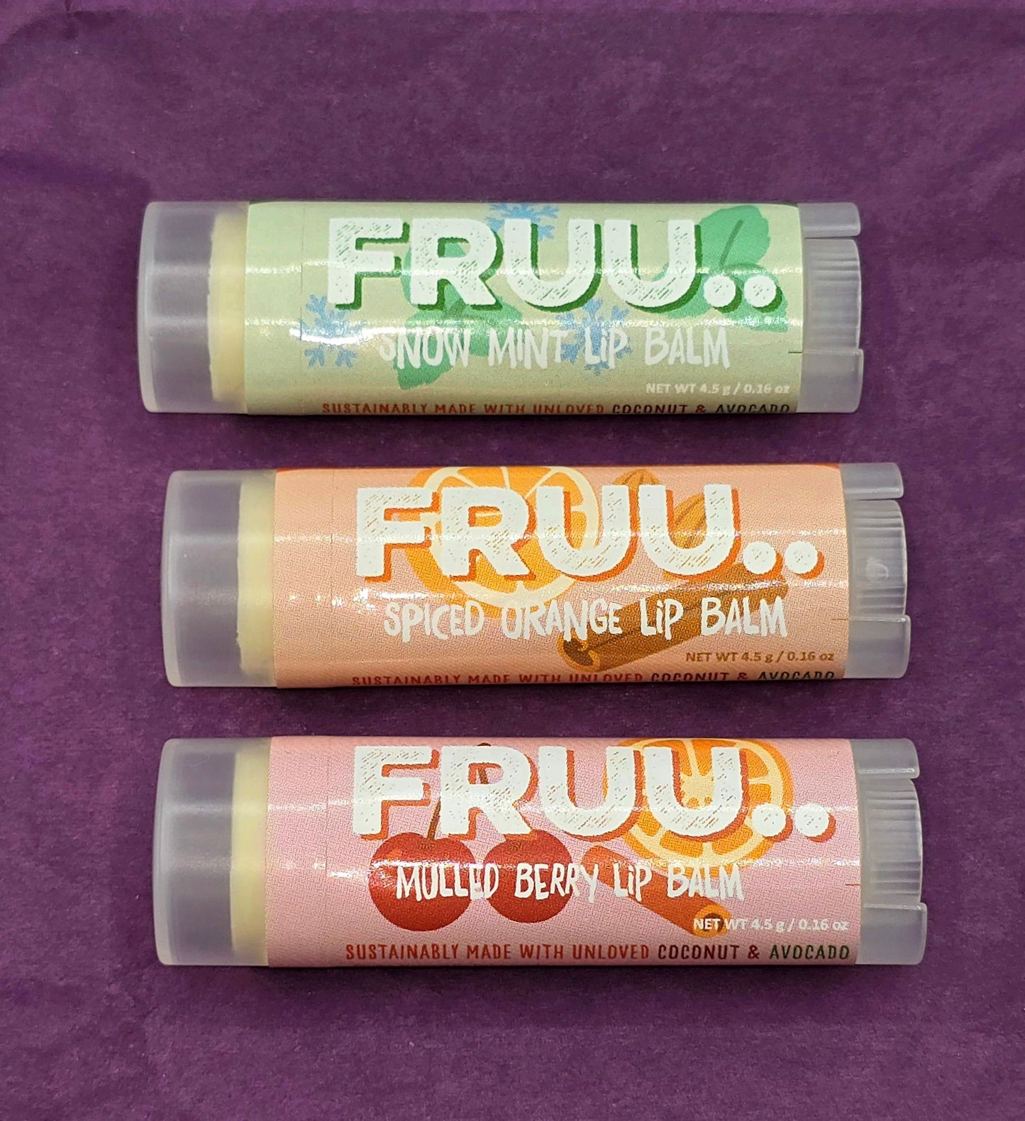 Three lip balm sticks from Fruu on a purple background