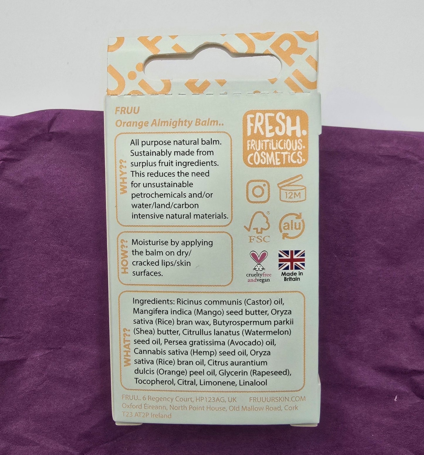 Packaging of Fruu Orange Almighty Balm on a purple background