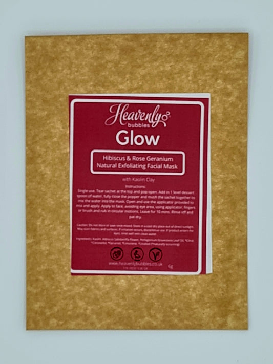 Brown kraft pouch with red label from Heavenly Bubbles stating "Glow, Hibiscus & Rose Geranium Natural Exfoliating Facial Mask with Kaolin Clay". 