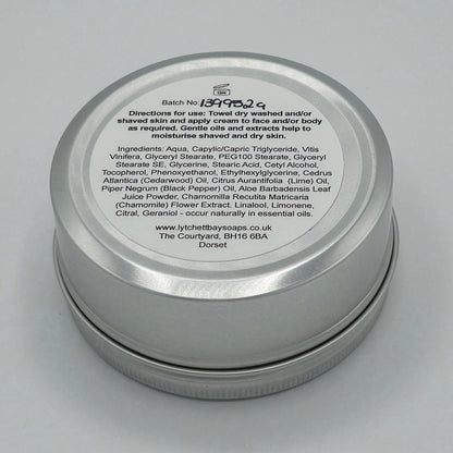 The back or bottom side of the silver tin containing Aftershave, Face & Body Cream for Men by Lytchett Bay Soaps. At the top of the label is that batch no, then bold text saying "Directions for use: Towel dry washed and/or shaved skin and apply cream to face and/or body as required. Gentle oils and extracts help to moisturise shaved and dry skin".
Half down the label there is text containing the ingredients. 