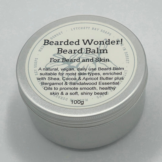 Round silver tin, around 7cm diameter, with light coloured label saying "Bearded Wonder! Beard Balm For Beard and Skin. A natural, vegan, daily use Beard Balm suitable for most skin-types, enriched with Shea, Cocoa & Apricot Butter plus Bergamot & Sandalwood Essential Oils to promote smooth, healthy skin & a soft, shiny beard. 100g".