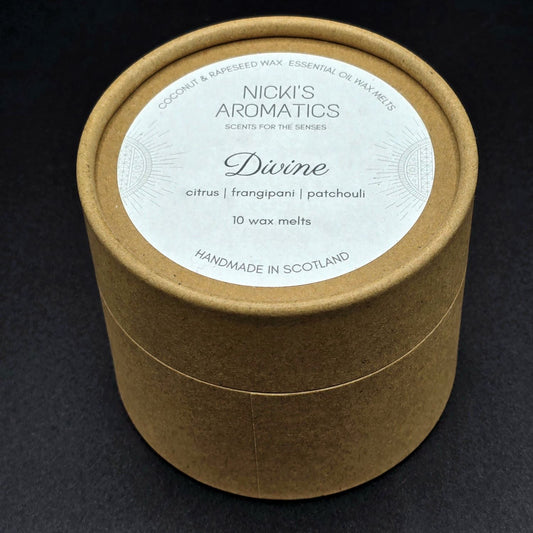 Brown kraft round cardboard box containing 10 wax melts from Nicki's Aromatics. The label says "Divine - Citrus, Frangipani, Patchouli".