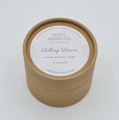 Round kraft cardboard box with a white label on the top with the text "Coconut & Rapeseed Wax Essential Oil Wax Melts" along the top. Below this is the logo for "Nicki's Aromatics" and the strapline "Scents for the Senses". In the middle of the label is the name "Falling Leaves" with "Orange", "Patchouli" "Ginger" and "10 wax melts" typed below. At the very bottom of the label is the wording "Handmade in Scotland".