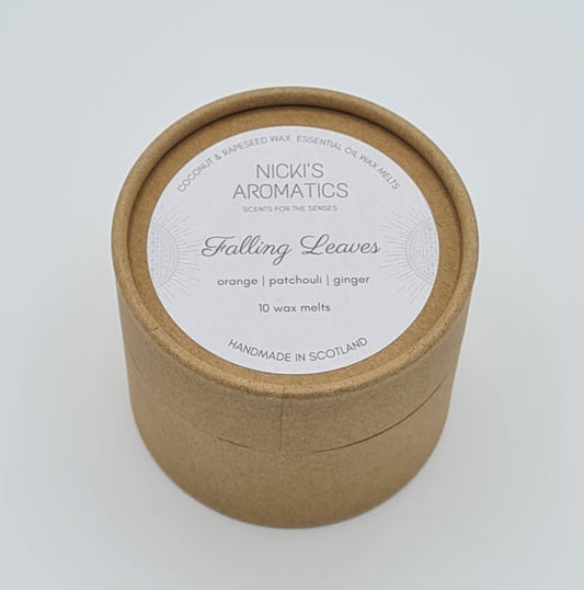 Round kraft cardboard box with a white label on the top with the text "Coconut & Rapeseed Wax Essential Oil Wax Melts" along the top. Below this is the logo for "Nicki's Aromatics" and the strapline "Scents for the Senses". In the middle of the label is the name "Falling Leaves" with "Orange", "Patchouli" "Ginger" and "10 wax melts" typed below. At the very bottom of the label is the wording "Handmade in Scotland".