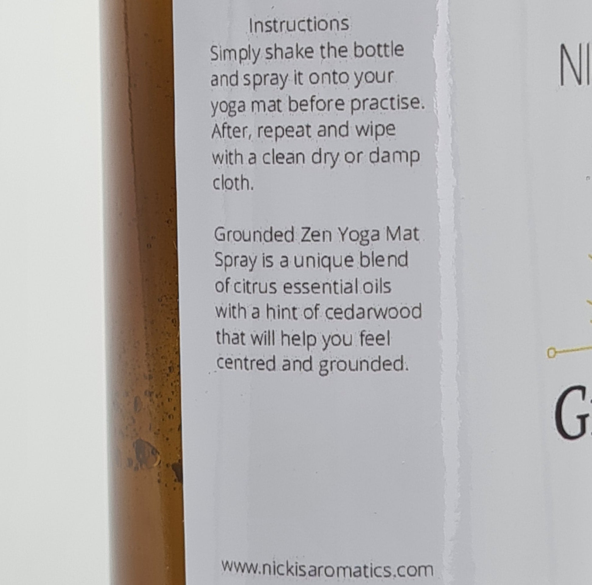 Close up of the side of the label for Grounded Zen Yoga Mat Spray. The text says:
"Instructions: Simply shake the bottle and spray it onto your yoga mat before practise. After, repeat and wipe with a clean dry or damp cloth.
Grounded Zen Yoga Mat Spray is a unique blend of citrus essential oils with a hint of cedarwood that will help you feel centred and grounded".
