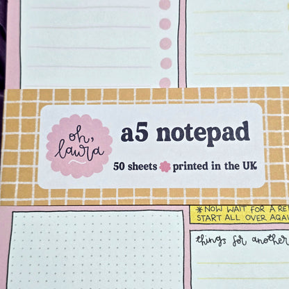 A5 notepad with grid and lined pages, featuring a label on top.