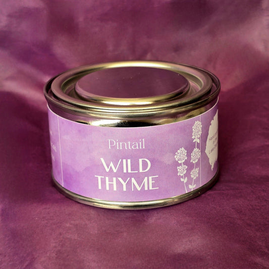 Petite paint pot candle tin from Pintail Candles. The lilac coloured label on the tin says "Wild Thyme" and features an illustration of white flowers.