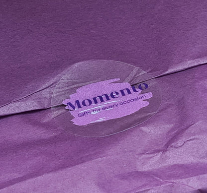 Close up of purple tissue paper sealed with sticker with the Momento logo