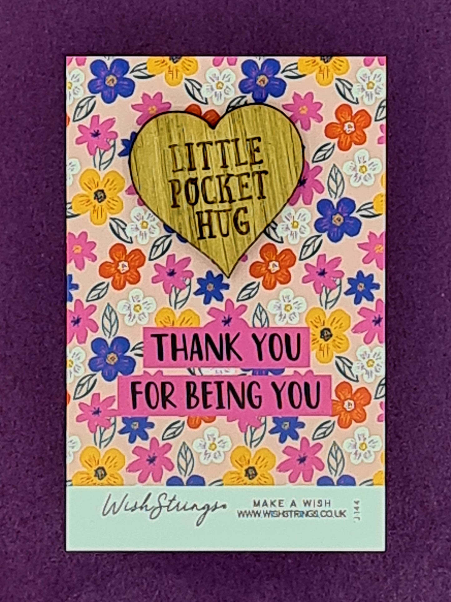 Small wooden heart shaped token saying "Little Pocket Hug". It is mounted on card with lots of different coloured flowers and the message "Thank You for Being You". 