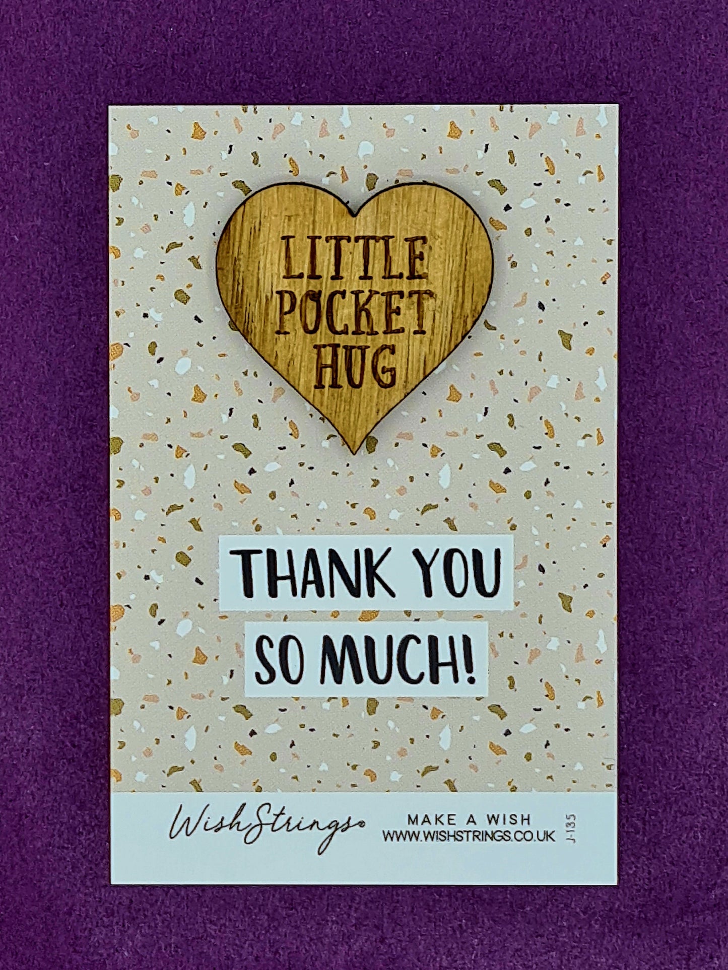 Small wooden heart shaped token saying "Little Pocket Hug". It is mounted on beige coloured card with a celebratory pattern and the message "Thank You so Much". 